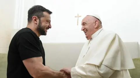 EPA Ukranian President Volodymyr Zelensky and Pope Francis shake hands and smile